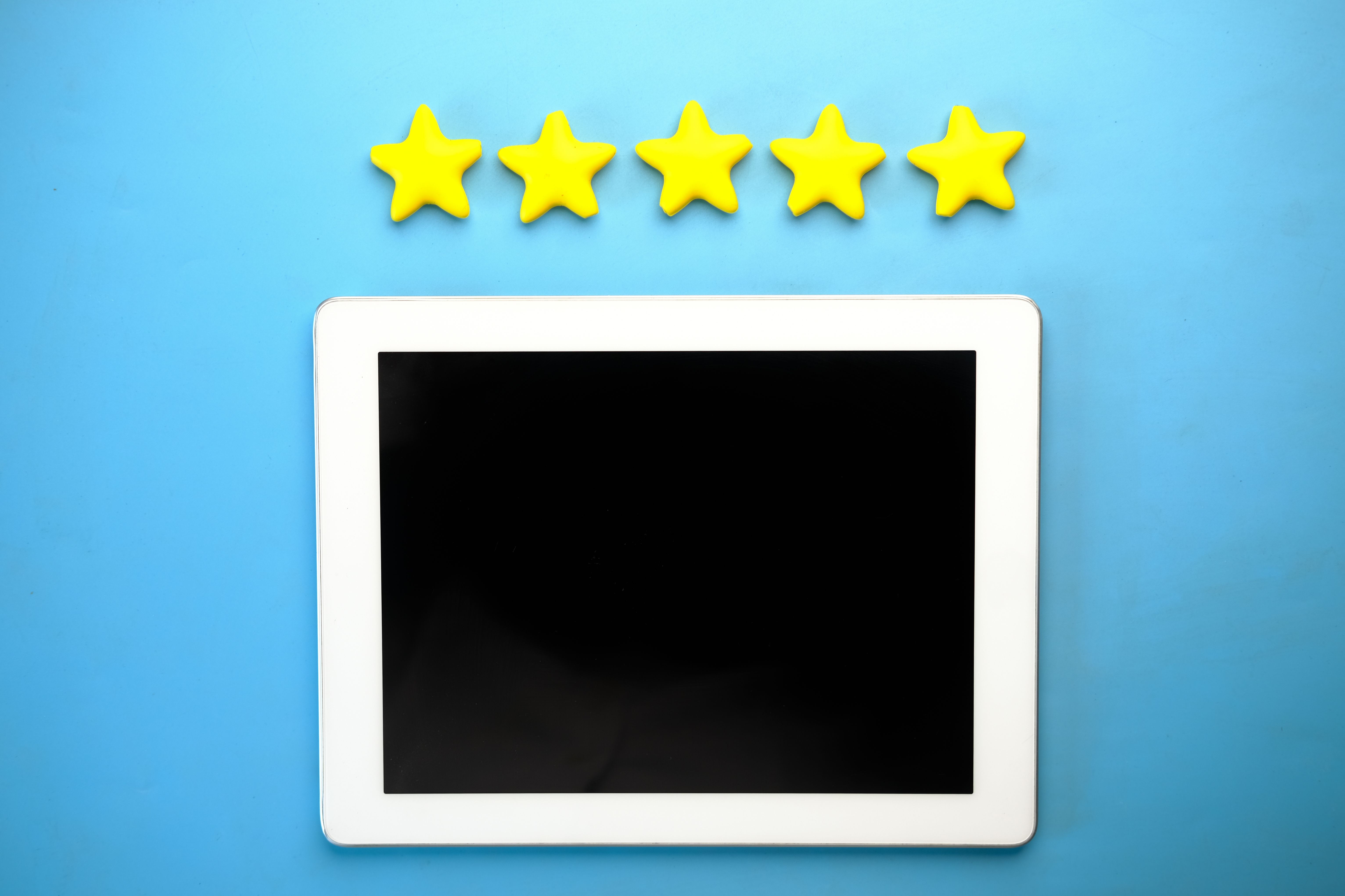 Tablet displaying five yellow stars representing local business customer reviews and ratings