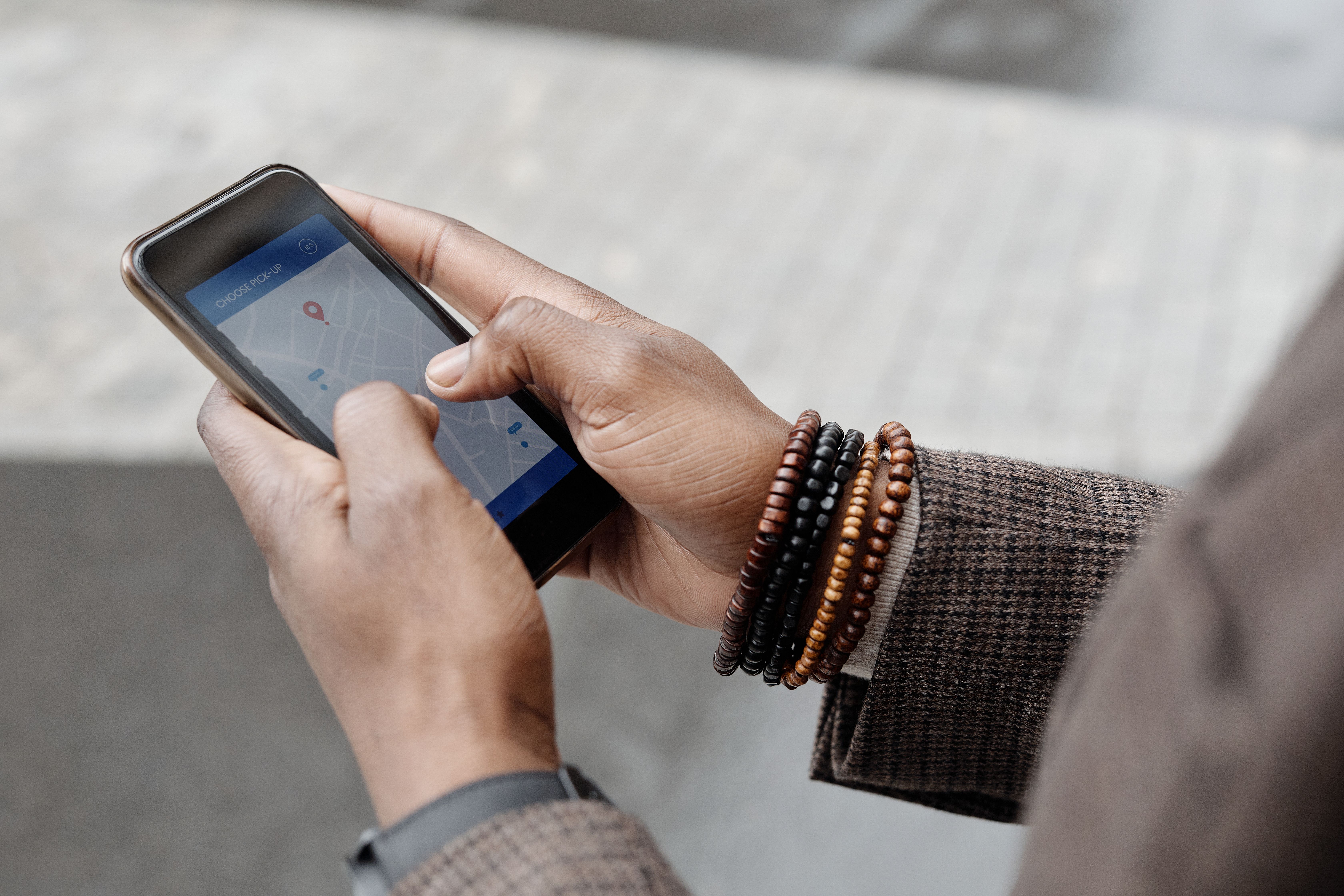 Close-up of hands using a GPS map app on a smartphone to find nearby services