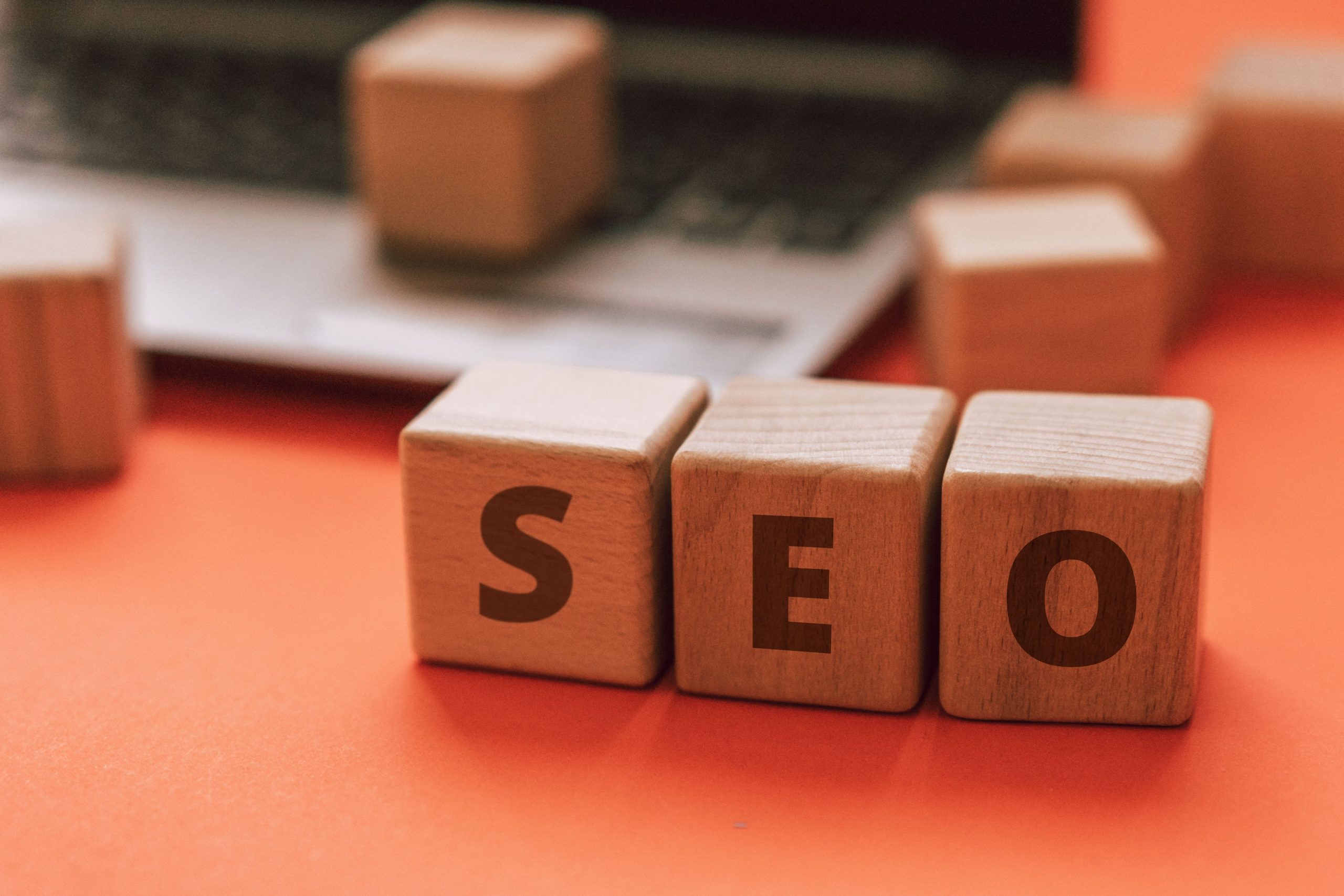 Wooden blocks spelling SEO on a laptop keyboard illustrating a local SEO strategy