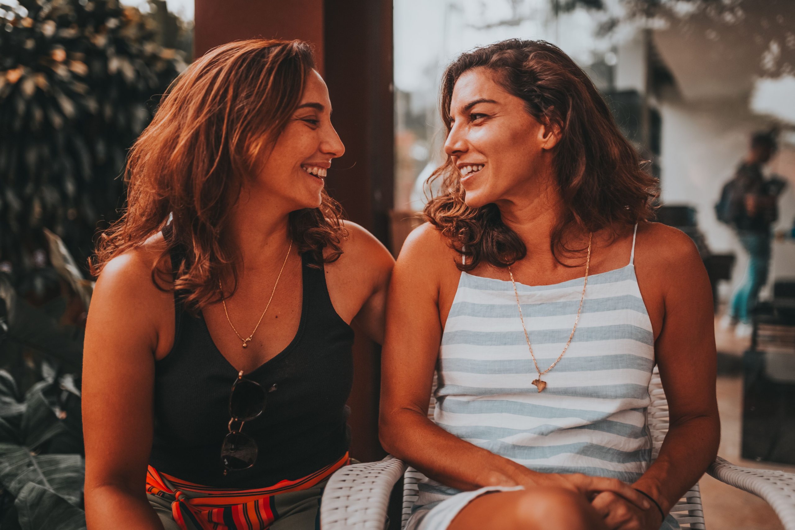 Two friends sharing a relaxed, smiling moment outdoors, illustrating everyday companionship.