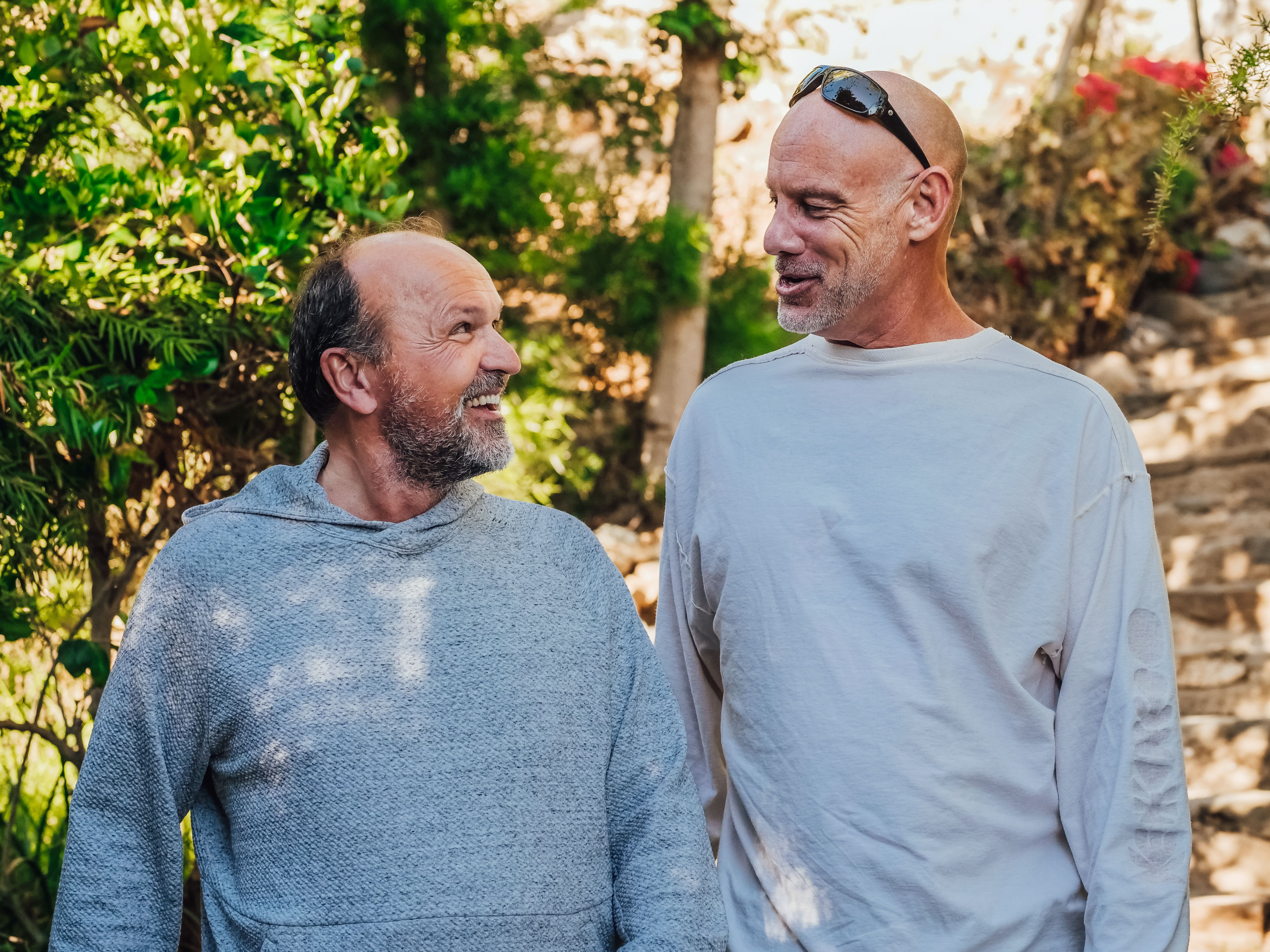 Two older friends share a joyful conversation outdoors, showing that meaningful companionship spans generations.