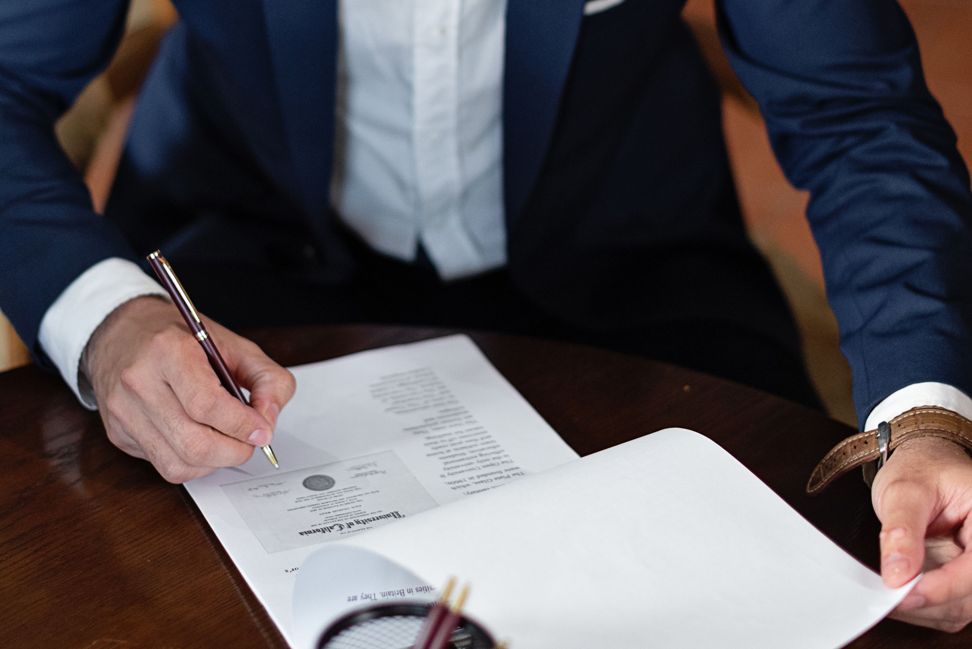 Professional signing legal documents at a desk, illustrating a third-party litigation finance contract